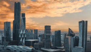 A panoramic view of Riyadh skyline at sunset, highlighting the KAFD Towers and modern architectural landmarks
